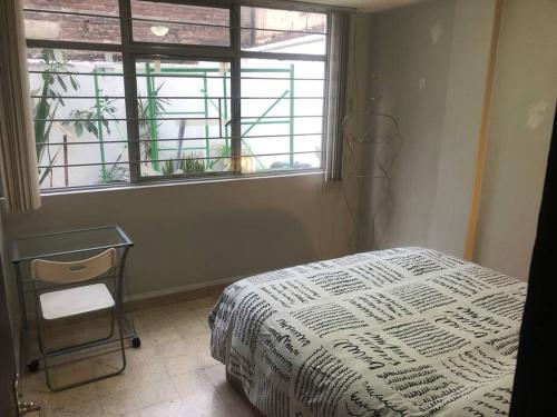 a bedroom with a bed and a window at Azul Photo Studio & Apartment in Mexico City
