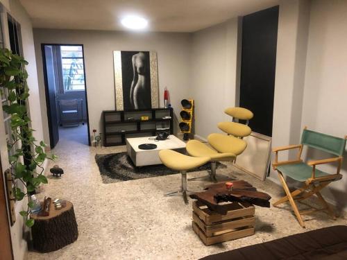 a living room with yellow chairs and a table at Azul Photo Studio & Apartment in Mexico City