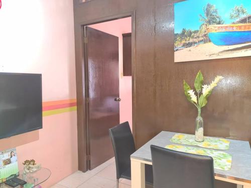 - une salle à manger avec une table et un vase dans l'établissement Affordable Condo for Rent near Emperor Events Place, à Cainta