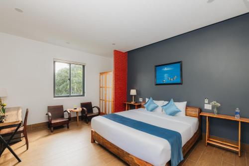 a bedroom with a large bed and a desk at Ngoc An Bang Villa in An Bang