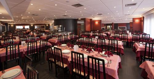 une salle à manger avec des tables et des chaises et du linge de maison rose dans l'établissement Hôtel Florida, à Lourdes