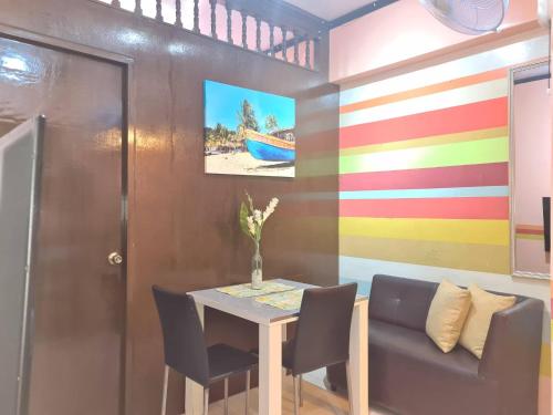 ein Esszimmer mit einem Tisch und Stühlen sowie einer farbenfrohen Wand in der Unterkunft Affordable Transient along Ortigas Ext near Cainta/Pasig in Cainta