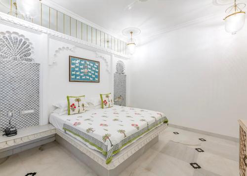 a white bedroom with a bed in a room at Jagat Niwas Palace in Udaipur