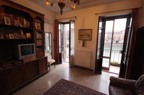 a living room with a television and a door to a balcony at Sottoriva36 in Verona