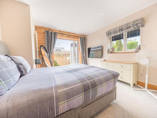 een slaapkamer met een bed en een raam bij The Lodge in Dalton in Furness