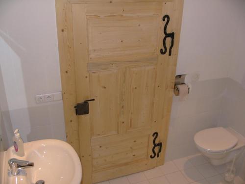 a bathroom with a door with snakes painted on it at Drevenica Traditional Cottage Old Centre in Zuberec