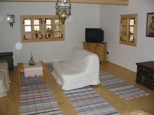 a living room with a white couch and a tv at Drevenica Traditional Cottage Old Centre in Zuberec