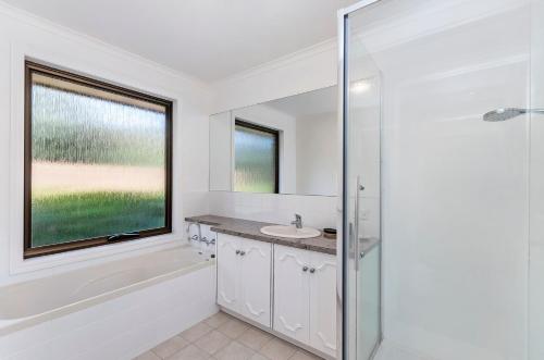 een witte badkamer met een wastafel en een douche bij Kings Head in Allansford