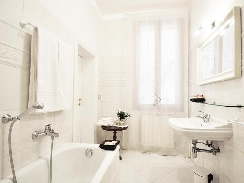 a white bathroom with a bath tub and a sink at La Casa del Mercante Veneziano in Venice