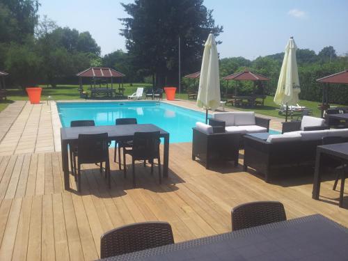 - une piscine avec des tables, des chaises, une table et des chaises dans l'établissement Logis Hôtel Restaurant La Vieille Ferme, Mâcon Nord, à Mâcon