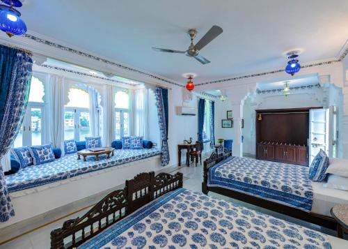 a blue bedroom with two beds and a tv at Jagat Niwas Palace in Udaipur