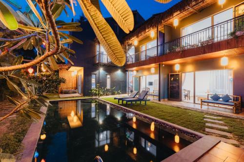 an image of a villa with a swimming pool at night at Ngoc An Bang Villa in An Bang