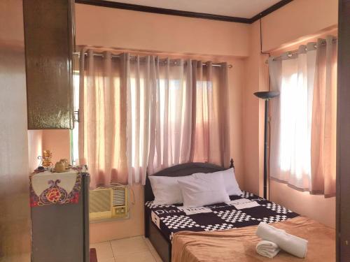 Habitación pequeña con cama y ventana en Budget Friendly Staycation in Valley Mansions en Cainta