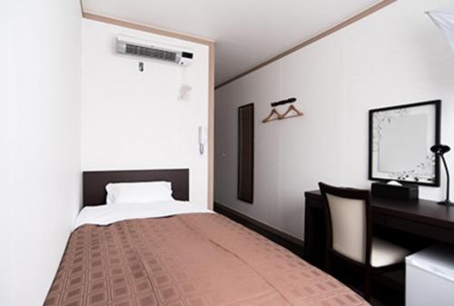 a bedroom with a bed and a desk at Hotel FRENTE HIRONO in Hirono