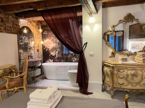 uma casa de banho com uma banheira e um lavatório e uma banheira em Casa al Ponte Scudi - 4 Windows on the Canal em Veneza