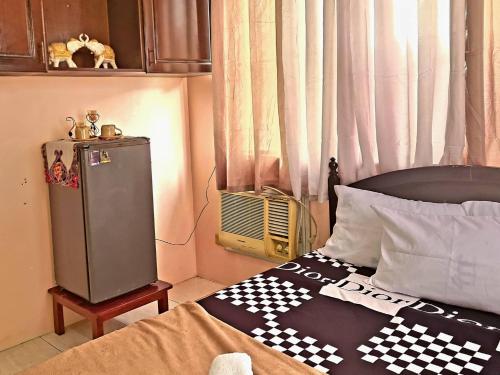 CaintaにあるBudget Friendly Condo for Rent in Valley Golfのベッドルーム(ベッドの上にチェック入りの毛布付)