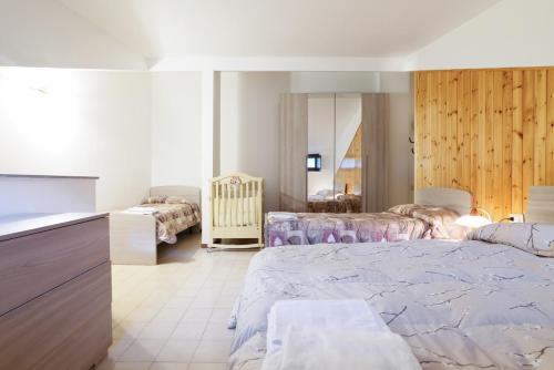 a bedroom with a large bed and a kitchen at Cambrembo a 3km da foppolo casa x6persone con Camino e Wifi in Valleve