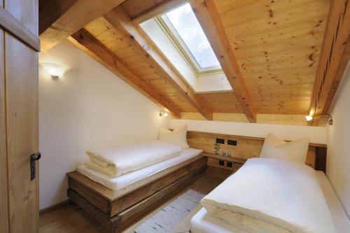 a small room with two beds and a skylight at Wimmerhof in Höslwang