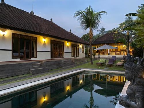 a villa with a swimming pool at night at Agung Village in Tanah Lot