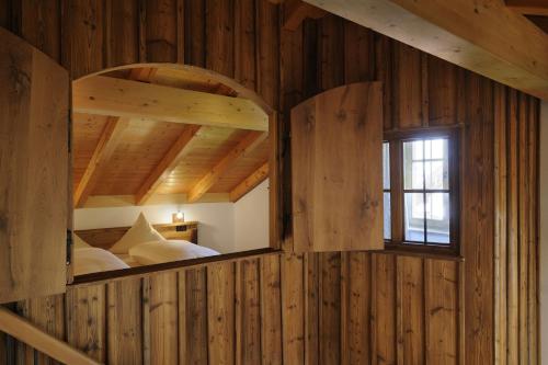 a bedroom with a large window in a wooden wall at Wimmerhof in Höslwang