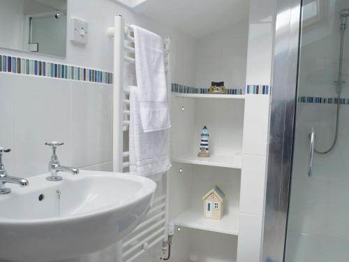 a white bathroom with a sink and a shower at Hayscastle Farmhouse in Hayscastle