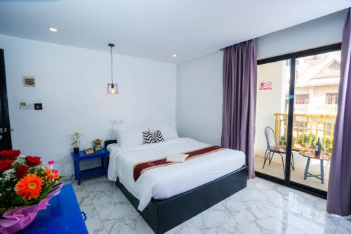 a hotel room with a bed and a balcony at The Rabbit Hole Hotel & SPA in Siem Reap