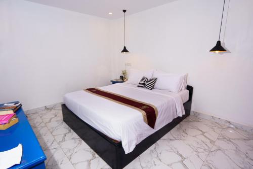 a bedroom with a large bed with white sheets and pillows at The Rabbit Hole Hotel & SPA in Siem Reap