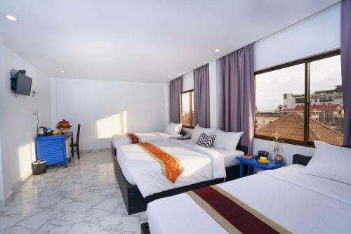 Habitación de hotel con 2 camas y ventana en The Rabbit Hole Hotel & SPA, en Siem Reap
