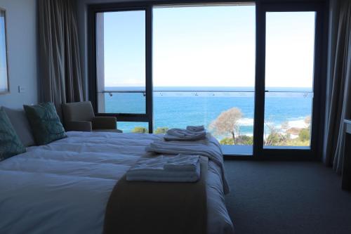 塔斯拉Tathra Hotel & Motel的一间带床的卧室，可欣赏海景