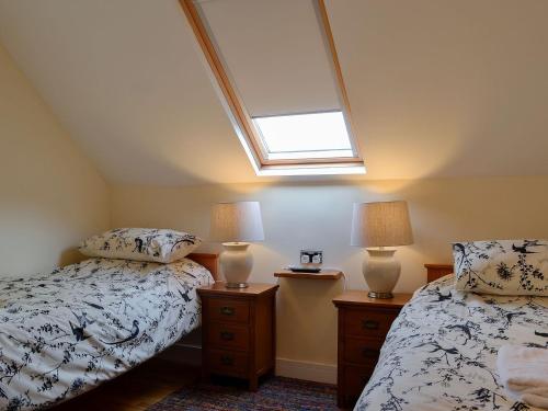 una camera mansardata con 2 letti e un lucernario di Ghillie Cottage a Cockermouth