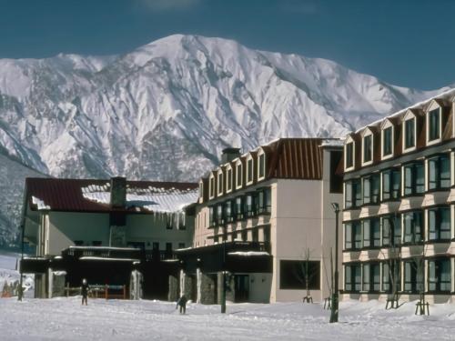 a group of buildings in front of a mountain at Hotel Onikoube in Osaki