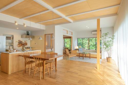 a kitchen and living room with a table and chairs at YAMO-Izukogen in Yawatano