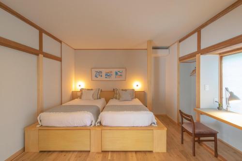 a bedroom with a large bed and a desk at YAMO-Izukogen in Yawatano