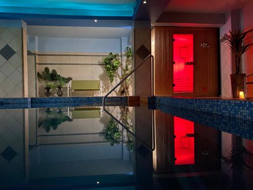 a house with a swimming pool with a red door at Gea Kaimaktsalan Hotel & Spa in Kato Loutraki