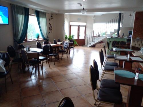 - une salle à manger avec des tables, des chaises et des fenêtres dans l'établissement Pensiunea Duet, à Sărata-Monteoru