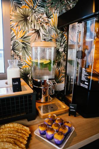 un comptoir avec un mixeur et quelques petits gâteaux sur une plaque dans l'établissement Cottages de France CDG, à Saint-Mard