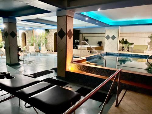 a swimming pool with a table and chairs in a house at Gea Kaimaktsalan Hotel & Spa in Kato Loutraki
