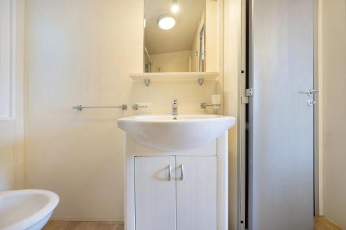 a bathroom with a white sink and a toilet at Camping Grande Italia Maddalena 6 in Chioggia
