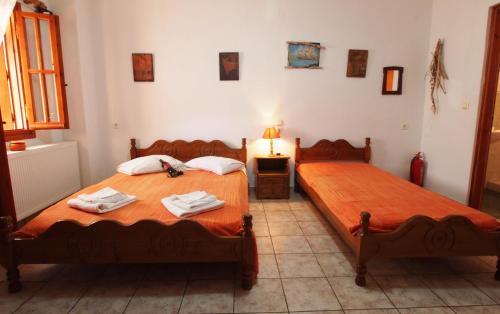 a bedroom with two beds with towels and a lamp at Andromahi Studios in Lefokastro