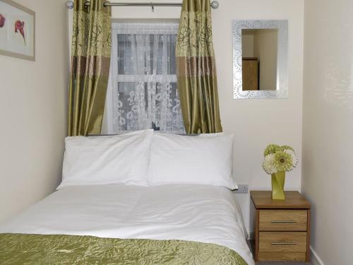 a bedroom with a white bed and a window at Mountain View in Blaenau-Ffestiniog