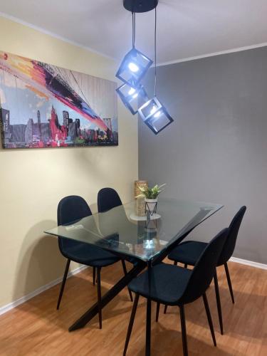 a dining room with a glass table and chairs at Amplio Depto en Viña del Mar con Estacionamiento. in Viña del Mar