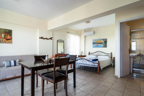 1 dormitorio y sala de estar con mesa de comedor. en Afroksilia Villa Yakinthos, en Katouna