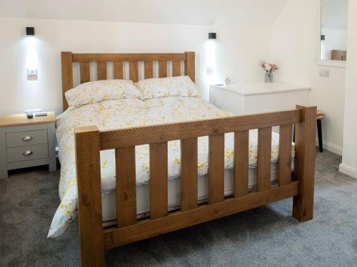 a bedroom with a wooden bed with a wooden frame at Coley Cottage in Wainfleet All Saints