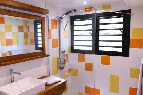 La salle de bains est pourvue d'un lavabo et d'une fenêtre. dans l'établissement LE TUIT TUIT, à Petite Île