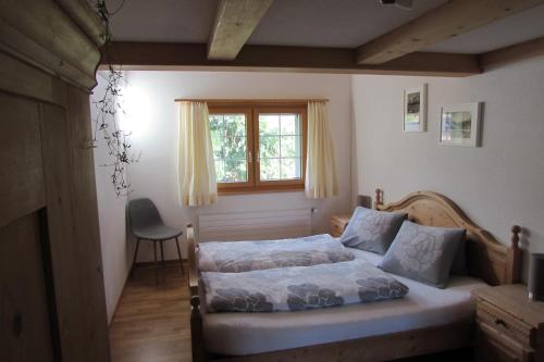 een slaapkamer met een bed, een raam en een stoel bij Wies in Stein