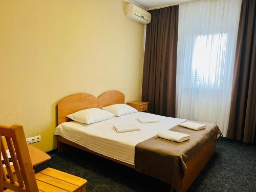 a bedroom with a bed with two towels on it at Hotel LaMa 2 in Kyiv