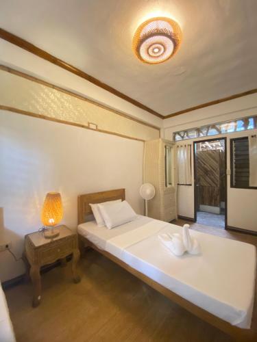 a bedroom with a bed and a lamp on a table at Tahanan Resort in San Juan
