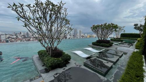 uma vista para uma piscina de água com bancos e árvores em Beacon Executive Suite - City View - By IZ em George Town