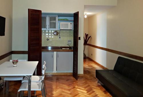 a living room with a couch and a table and a kitchen at Studio Maipu in Buenos Aires