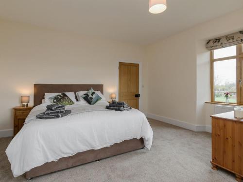 a bedroom with a large bed and a window at The Farmhouse - Uk10655 in West Pennard